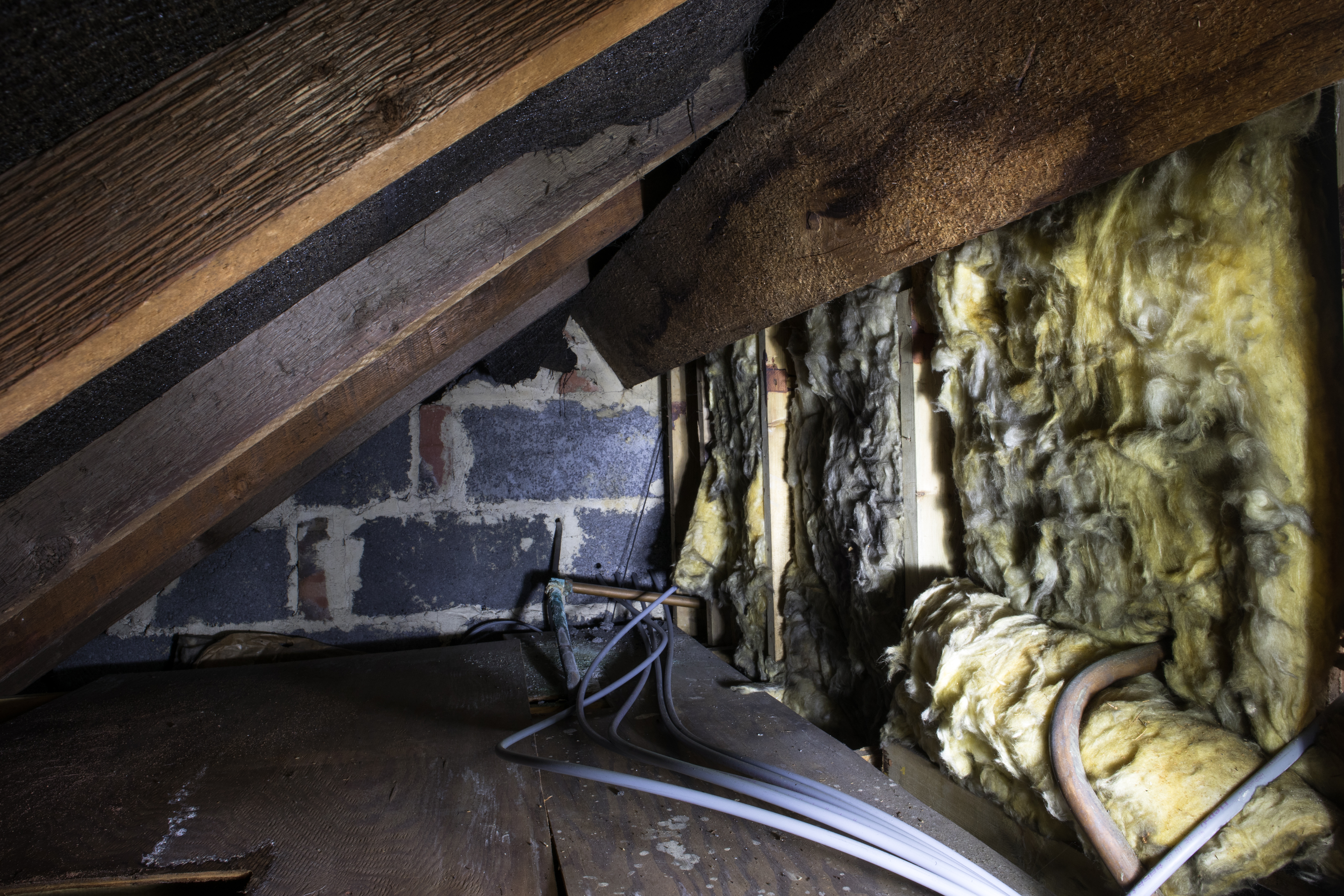Crawl space under the eves of a house showing insulation